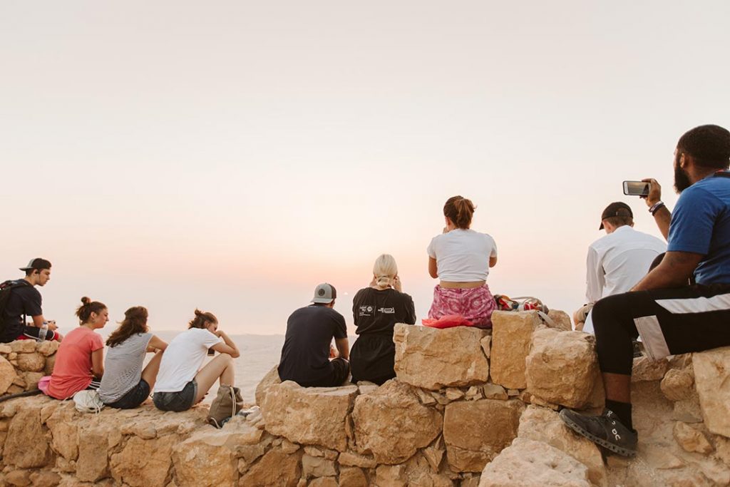 people watching the sunrise at masada