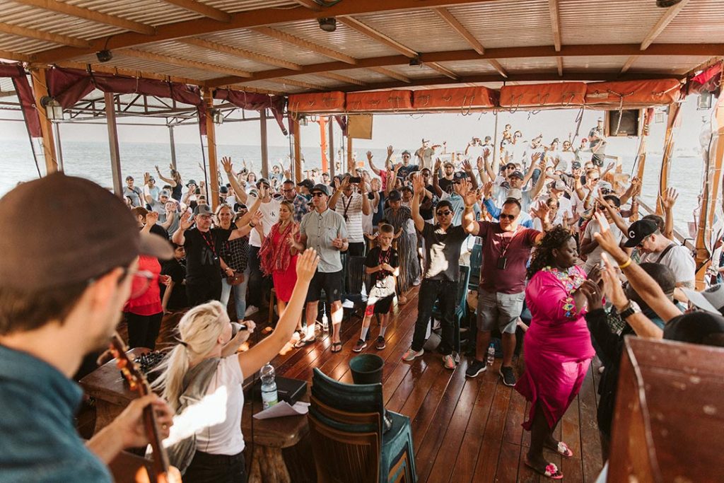 group of people worshipping on a boat on sea of galilee