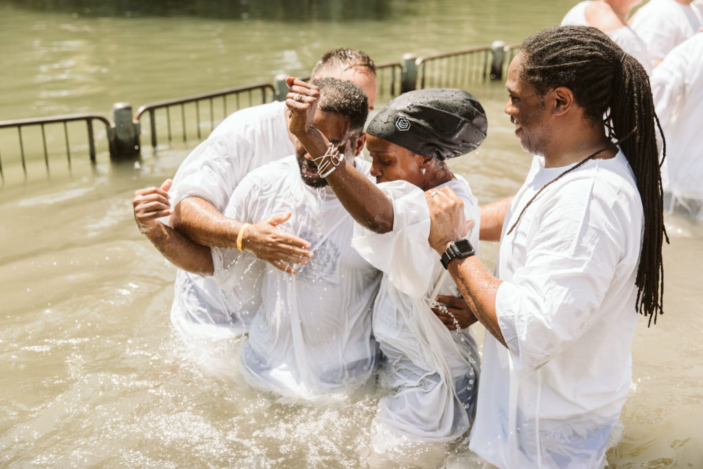 group of tourists getting baptized in the jordan river