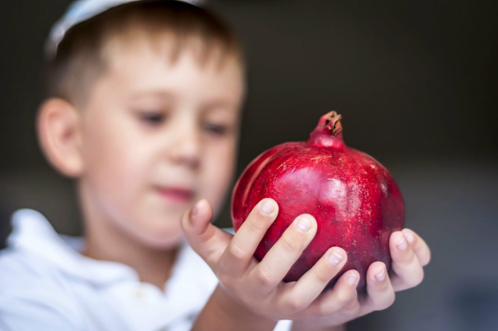kid holding a pomegranate 
